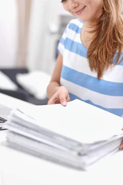 Glimlachende vrouw met documenten op het bureau met laptop. — Stockfoto