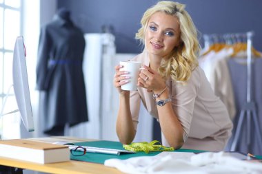 Moda tasarımcısı kadın stüdyoda tasarımları üzerinde çalışıyor..
