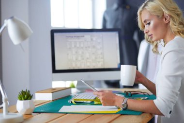 Moda tasarımcısı kadın stüdyoda tasarımları üzerinde çalışıyor..