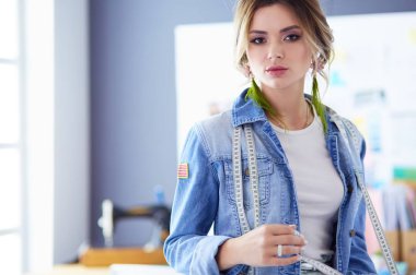 Moda tasarımcısı kadın stüdyoda tasarımları üzerinde çalışıyor.