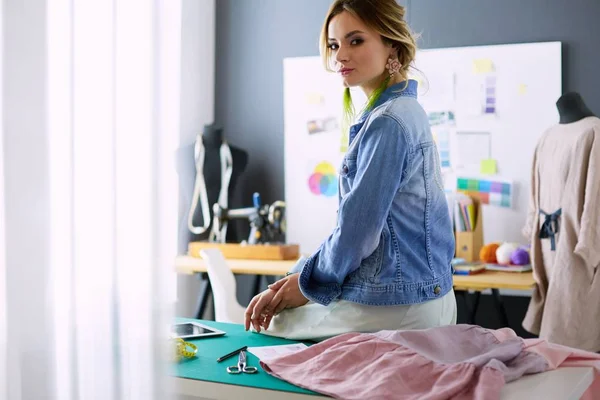 Mulher designer de moda trabalhando em seus projetos no estúdio — Fotografia de Stock