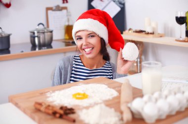 Kadın mutfakta Noel kurabiyesi yapıyor.