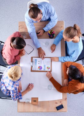 İş adamları toplantıda, ofiste oturup tartışıyorlar.