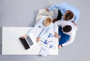 İş adamları toplantıda, ofiste oturup tartışıyorlar.