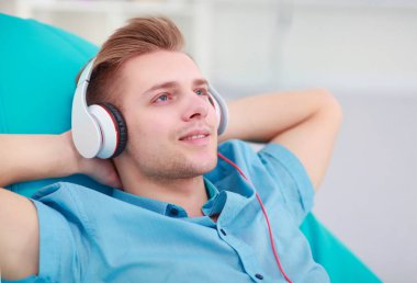 Adam evde kulaklık ile müzik dinleme