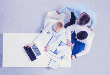 İş adamları toplantıda, ofiste oturup tartışıyorlar.