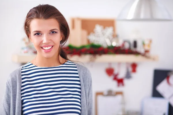 Portret van jonge vrouw tegen keuken interieur achtergrond — Stockfoto