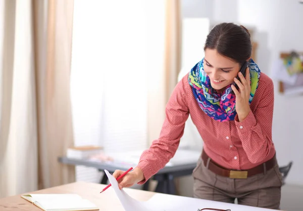 Beautiful fashion designer sitting at the desk in studio — Stock Photo, Image