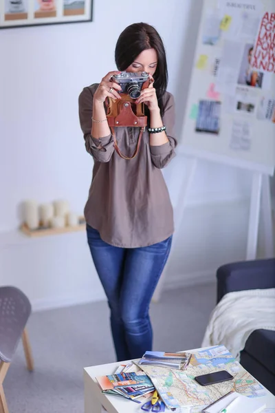 Portrét usměvavé mladé ženy s kamerou sedí v Loftový byt — Stock fotografie