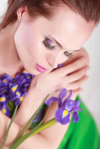 Hermosa mujer joven sosteniendo flores sobre fondo blanco — Foto de Stock