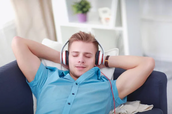 Homem ouvindo música com fones de ouvido em casa — Fotografia de Stock