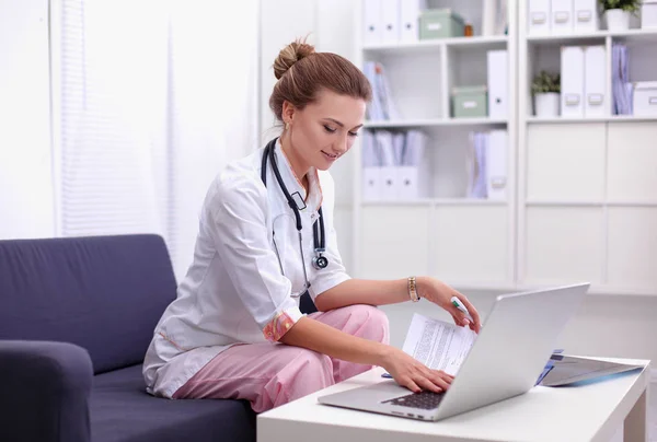 Closeup portrait of a young doctor sitting on the sofa — Stock Photo, Image