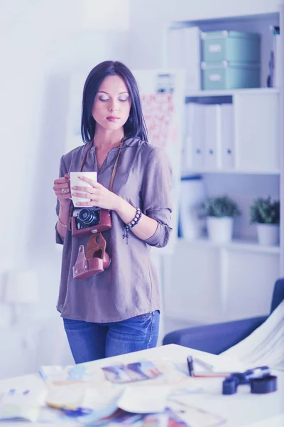 Porträtt av leende ung kvinna med kameran sitter i loftlägenhet — Stockfoto