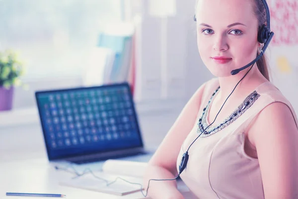 Vacker affärskvinna som arbetar vid sitt skrivbord med headset och laptop — Stockfoto