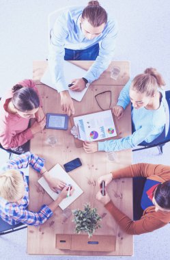 İş adamları toplantıda, ofiste oturup tartışıyorlar.