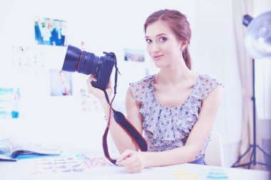 Masanın yanında genç ve güzel bir fotoğrafçının portresi.