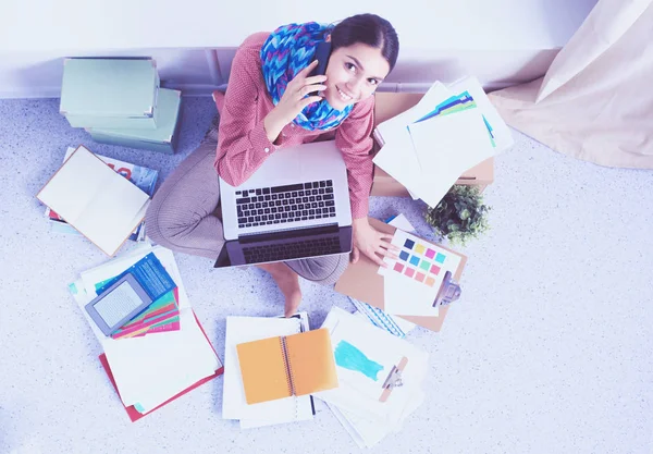 Schöne Modedesignerin sitzt am Schreibtisch im Atelier — Stockfoto