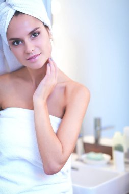 Banyo aynası önünde duran genç çekici kadın