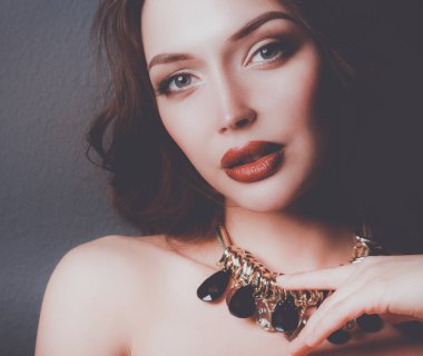 Sandalyede oturan güzel bir kadın, arka planda izole edilmiş. Güzel kadın..