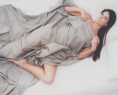 Evdeki yatakta uzanmış güzel esmer