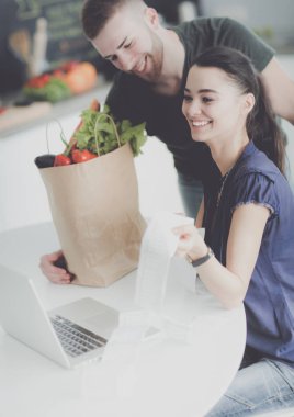 Çift evde mutfak içinde laptop ile onların fatura ödeme
