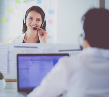 Ofisinde kulaklık ve bilgisayarla gülümseyen iş kadını ya da yardım hattı operatörü