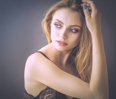 Güzel genç bir kadın beyaz yatakta yatıyor.