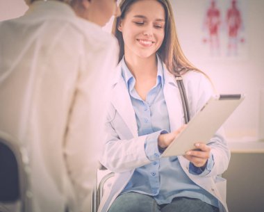 Doktor ve hasta masada otururken bir şey tartışıyorlar. İlaç ve sağlık hizmetleri kavramı