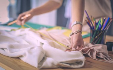 Moda tasarımcısı kadın stüdyoda tasarımları üzerinde çalışıyor..