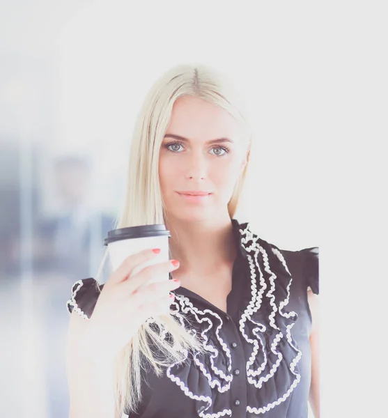 Empresaria sosteniendo una taza de café de pie en la oficina  . — Foto de Stock