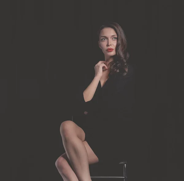 Mooie vrouw zit op een stoel, geïsoleerd op gebrek aan achtergrond. Mooie vrouw.. — Stockfoto