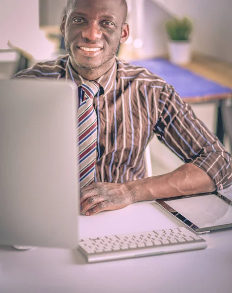 Handsome afro american businessman in classic suit is using a laptop and smiling while working in office — Stock Photo, Image