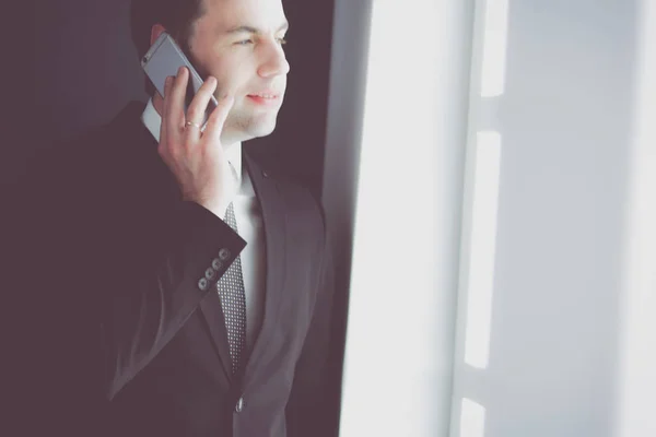 Beau homme d'affaires parlant sur téléphone portable dans le bureau moderne. — Photo