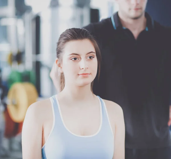 Beautiful woman at the gym exercising with her trainer. Beautiful woman. Gym.