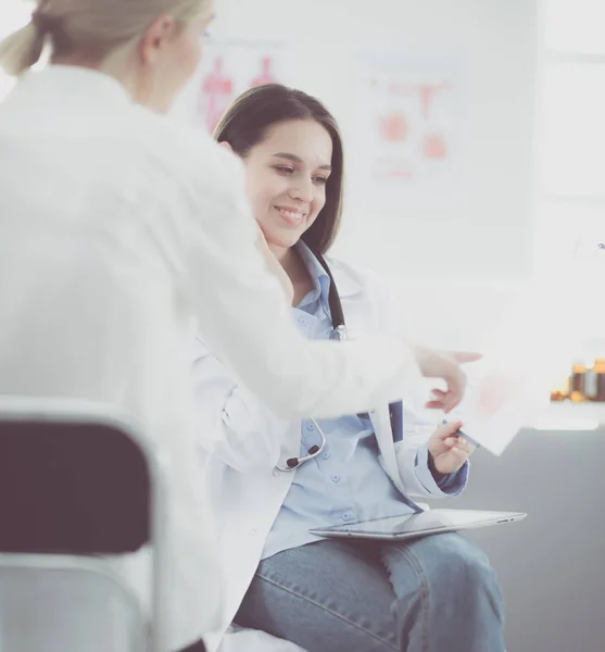 Arzt und Patient diskutieren etwas, während sie am Tisch sitzen. Medizin und Gesundheitskonzept — Stockfoto