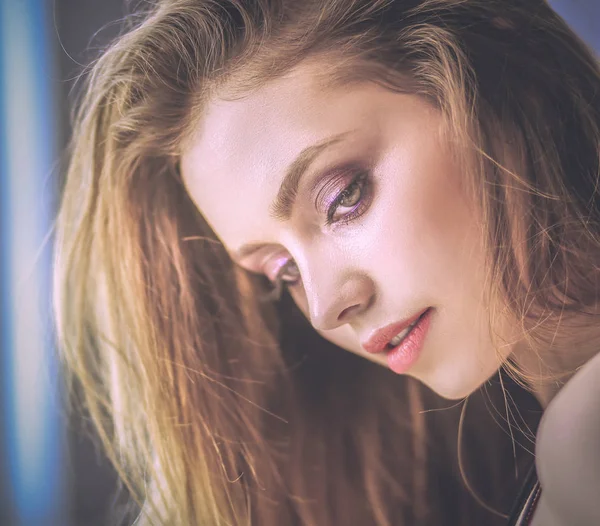 Güzel genç bir kadın beyaz yatakta yatıyor.