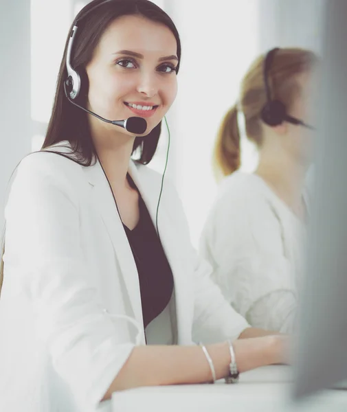 Ofisinde kulaklık ve bilgisayarla gülümseyen iş kadını ya da yardım hattı operatörü — Stok fotoğraf