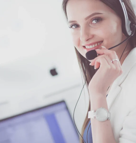Mujer de negocios sonriente u operador de línea de ayuda con auriculares y computadora en la oficina —  Fotos de Stock