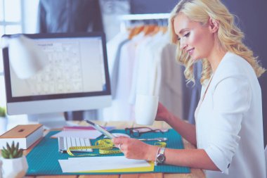 Moda tasarımcısı kadın stüdyoda tasarımları üzerinde çalışıyor..