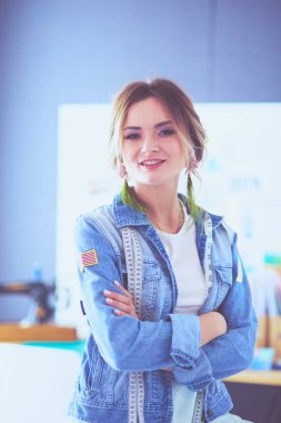 Moda tasarımcısı kadın stüdyoda tasarımları üzerinde çalışıyor.