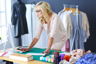 Moda tasarımcısı kadın stüdyoda tasarımları üzerinde çalışıyor..