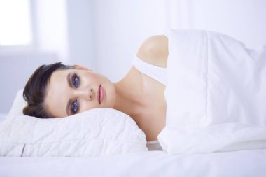 Genç ve güzel bir kadın yatakta yatıyor..