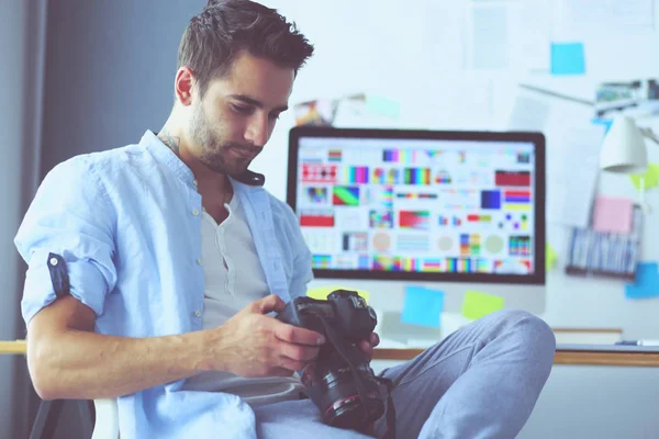 Porträt eines jungen Designers, der im Grafikstudio vor Laptop und Computer sitzt, während er online arbeitet. — Stockfoto