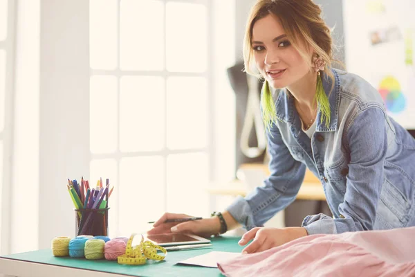 Diseñadora de moda mujer trabajando en sus diseños en el estudio — Foto de Stock