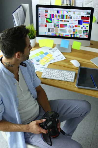 Porträtt av ung designer sitter i grafisk studio framför bärbar dator och dator när du arbetar online. — Stockfoto