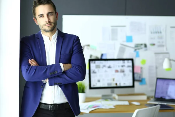 Porträt eines jungen Designers vor Laptop und Computer während der Arbeit. — Stockfoto