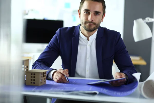 Businessman holding house miniature on hand standing in office. — Stock Photo, Image