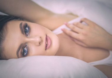 Genç ve güzel bir kadın yatakta yatıyor..