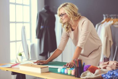 Moda tasarımcısı kadın stüdyoda tasarımları üzerinde çalışıyor..