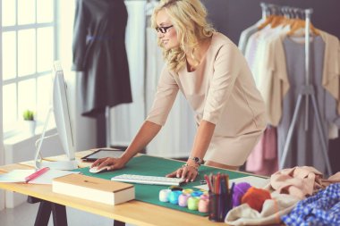 Moda tasarımcısı kadın stüdyoda tasarımları üzerinde çalışıyor..